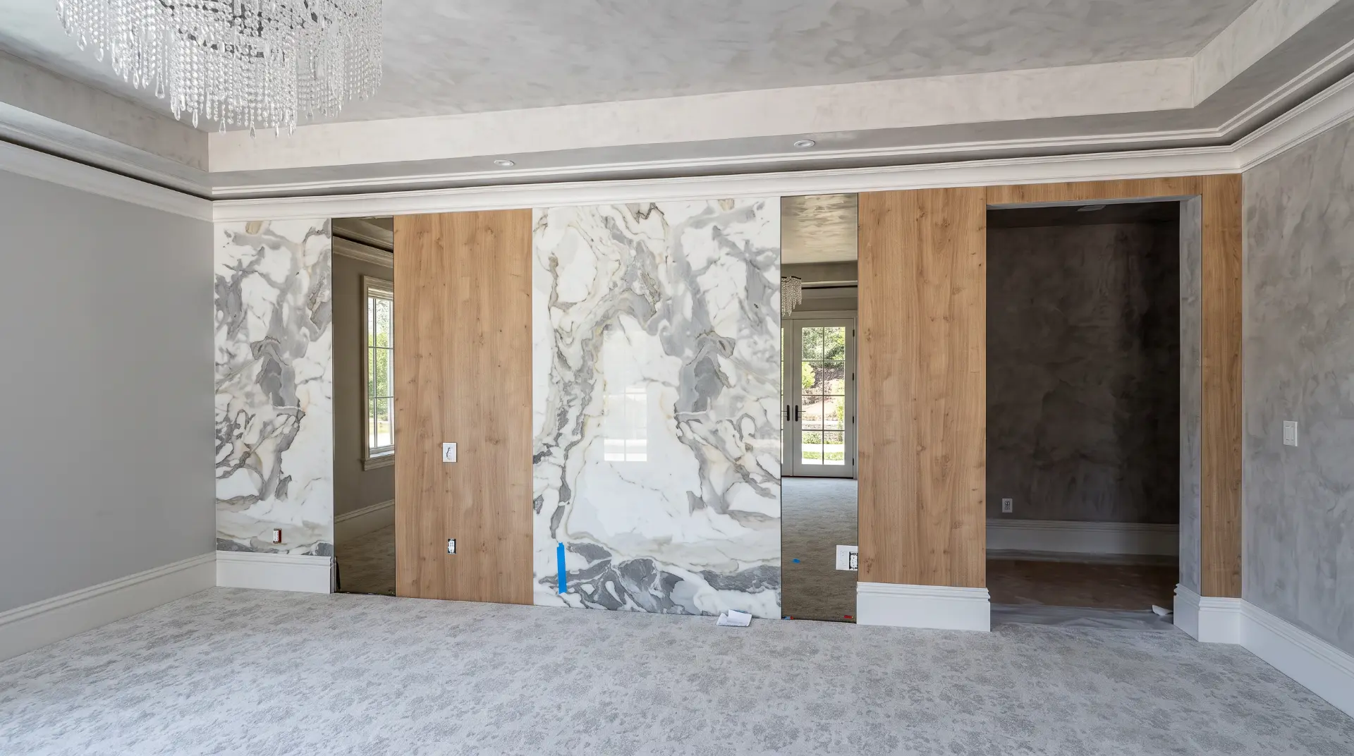 Marble and wood paneled accent wall in progress with mirrored inserts