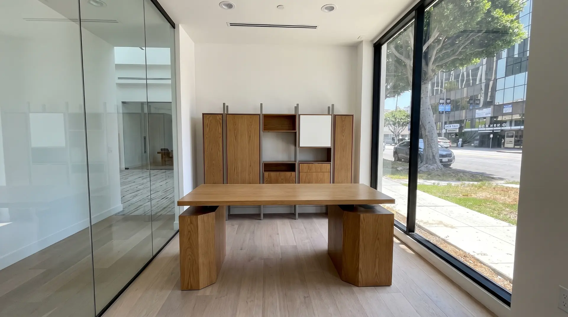 White oak office desk and shelving unit in a glass walled Los Angeles suite