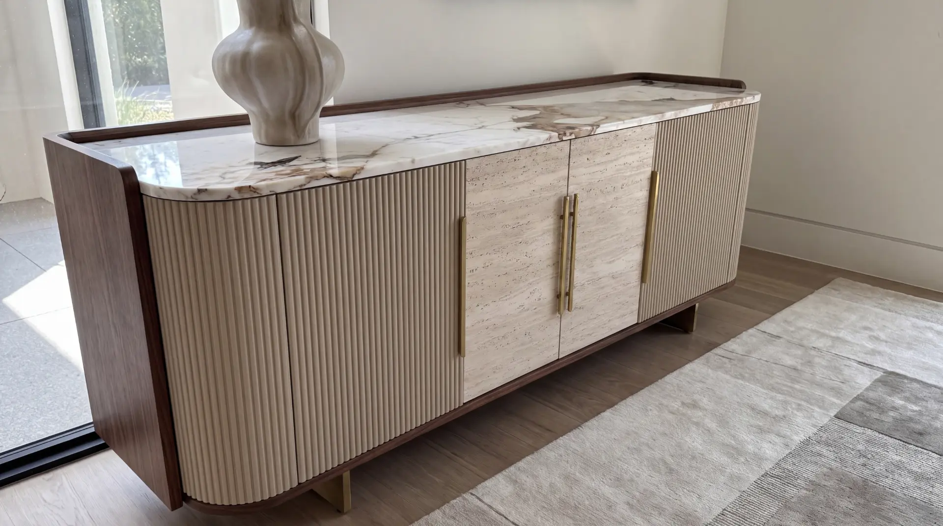Fluted credenza with Calacatta marble top, travertine doors, and brass hardware